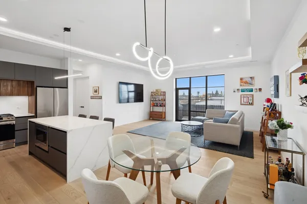 a living room with kitchen island furniture and a flat screen tv