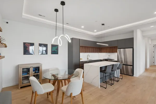 a kitchen with stainless steel appliances a table chairs and a refrigerator