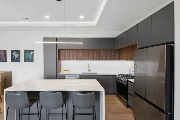 a kitchen with a sink a refrigerator and chairs