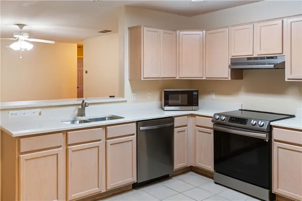 a kitchen with granite countertop white cabinets and a stove