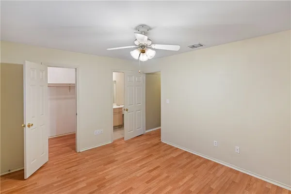 a view of a room with wooden floor and a ceiling fan