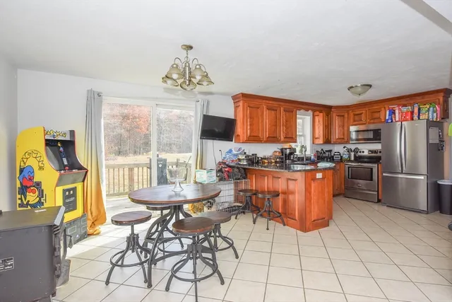 a kitchen with stainless steel appliances a table and chairs