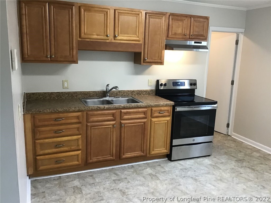 3334 Raintree Drive Fayetteville, NC 28304 - Photo 8 of 11 a kitchen with stainless steel appliances granite countertop a sink stove and cabinets