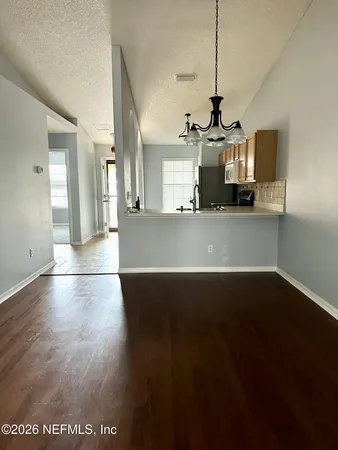 a view of a kitchen with wooden floor and a sink