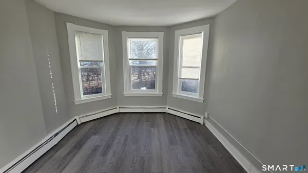 a view of a room with wooden floor and a hallway
