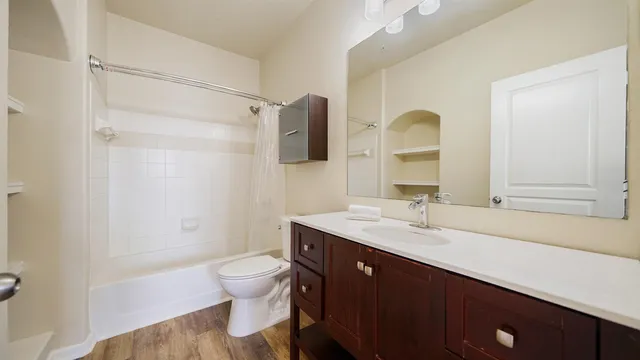 a bathroom with a granite countertop sink toilet a mirror and shower