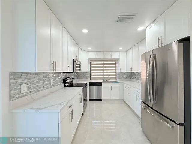 a kitchen with granite countertop white cabinets and white appliances
