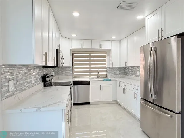 a kitchen with appliances cabinets and a counter top space