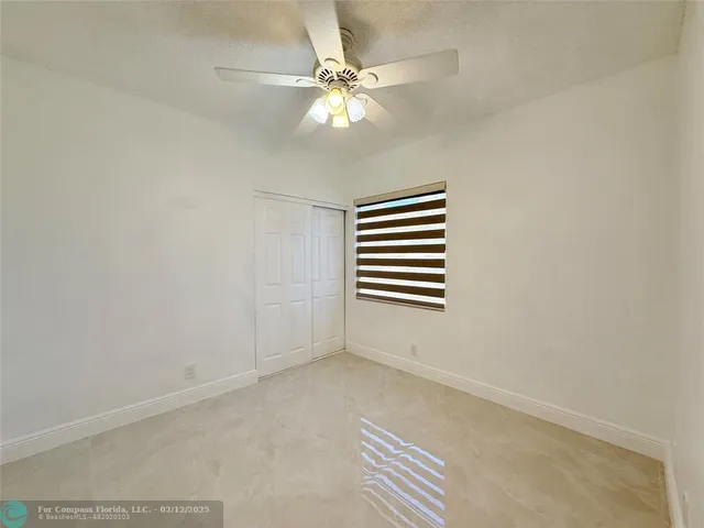 a view of room with a ceiling fan and window