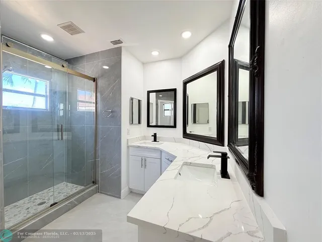 a white toilet sitting next to a white sink and vanity