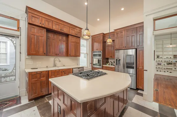 a kitchen with stainless steel appliances a refrigerator a stove and white cabinets