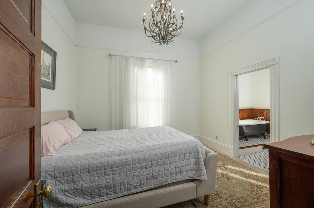 715 Broadway Columbus, GA 31901 - Photo 43 of 75 a bedroom with a bed and a chandelier