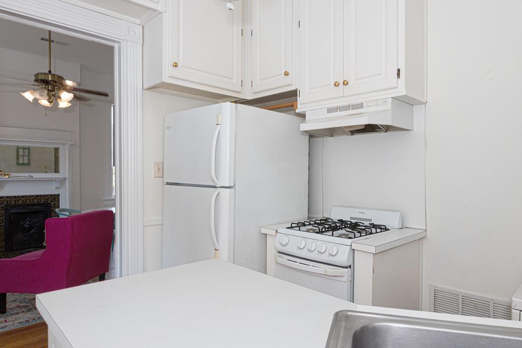 715 Broadway Columbus, GA 31901 - Photo 60 of 75 a kitchen with stainless steel appliances a refrigerator a stove and white cabinets