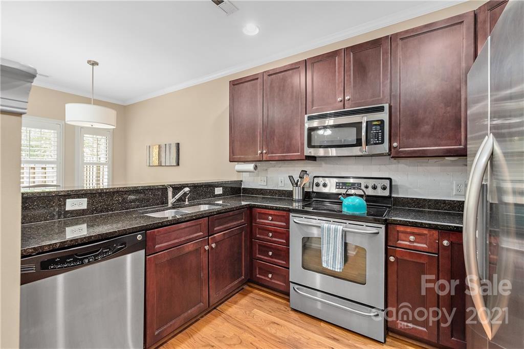 4617 Dabney Vigor Drive Charlotte, NC 28209 - Photo 8 of 23 a kitchen with granite countertop wooden cabinets stainless steel appliances and a sink