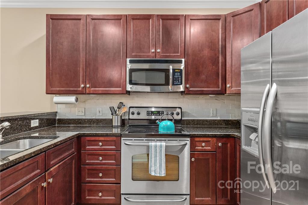 4617 Dabney Vigor Drive Charlotte, NC 28209 - Photo 10 of 23 a kitchen with granite countertop wooden cabinets and stainless steel appliances
