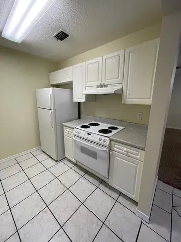 a kitchen with cabinets and white appliances