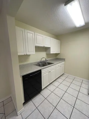 a kitchen with a sink cabinets and a window