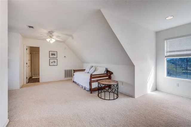 a spacious bedroom with a bed and a chandelier