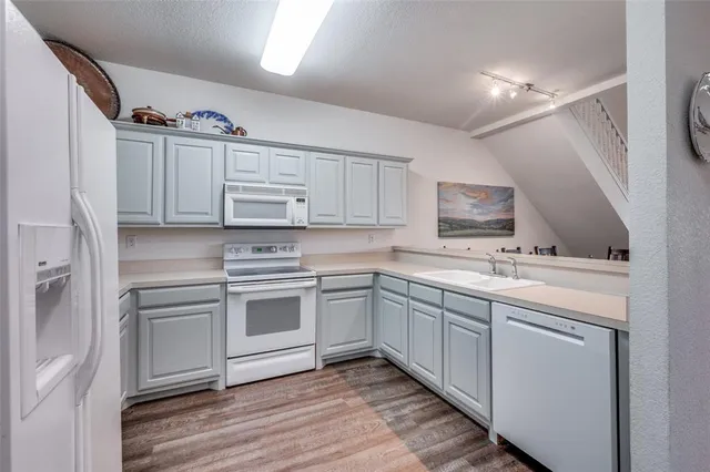 a kitchen with cabinets stainless steel appliances and a sink