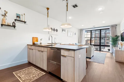 a kitchen with stainless steel appliances granite countertop a sink a stove and a wooden floors