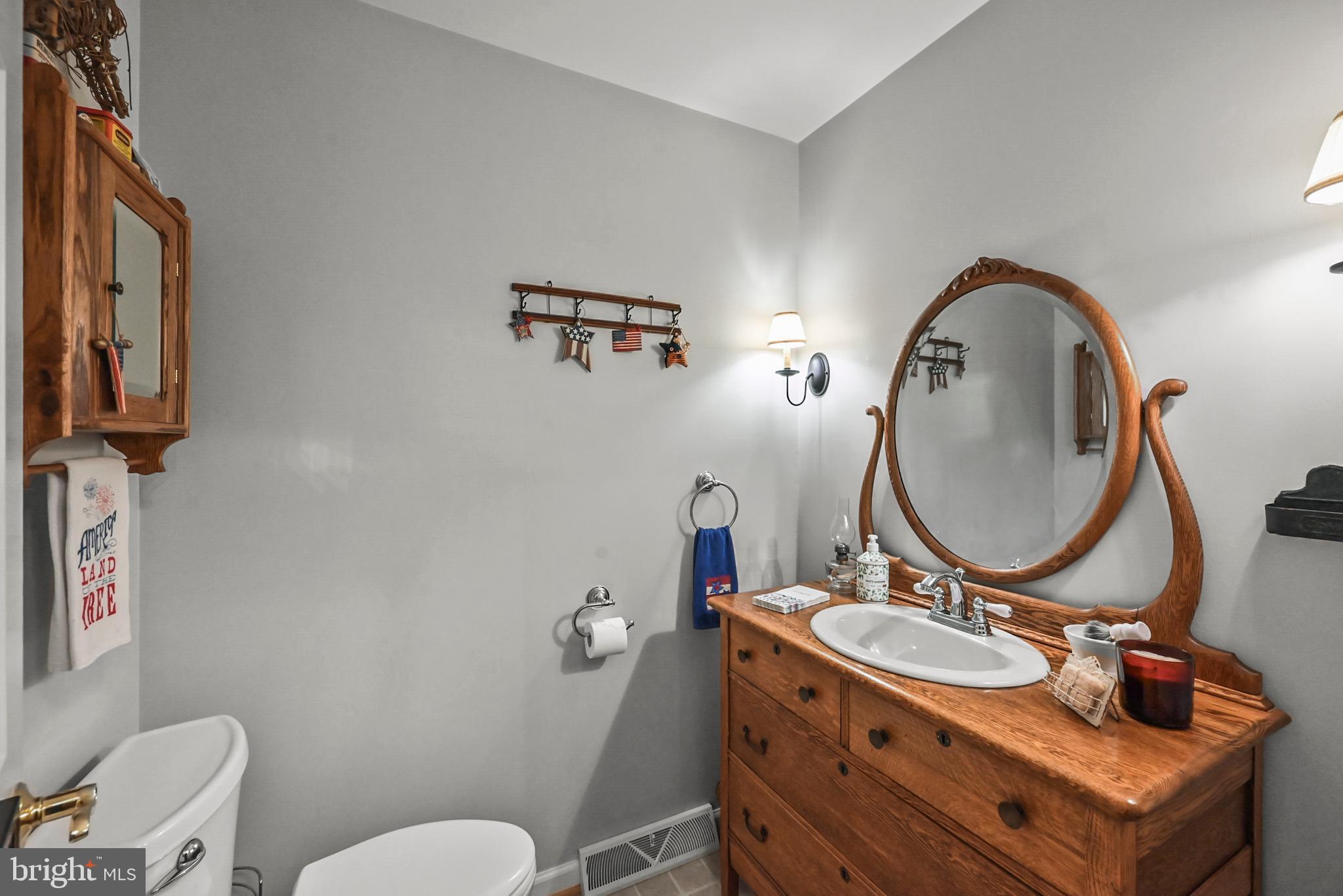 961 Beaver Creek Road Hanover, PA 17331 - Photo 26 of 52 a bathroom with a granite countertop toilet a mirror and a sink
