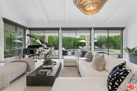 a dining room with furniture potted plants and a chandelier