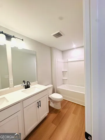 a bathroom with a double vanity sink toilet and a bathtub