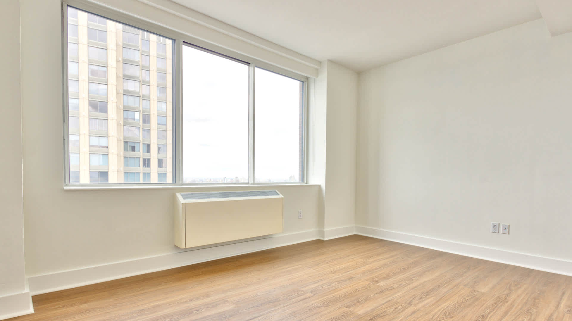 180 Riverside Boulevard, Unit 12A Manhattan, NY 10069 - Photo 10 of 11 a view of an empty room with wooden floor and a window