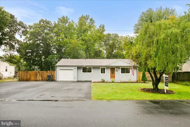 a view of a house with a big yard and large tree