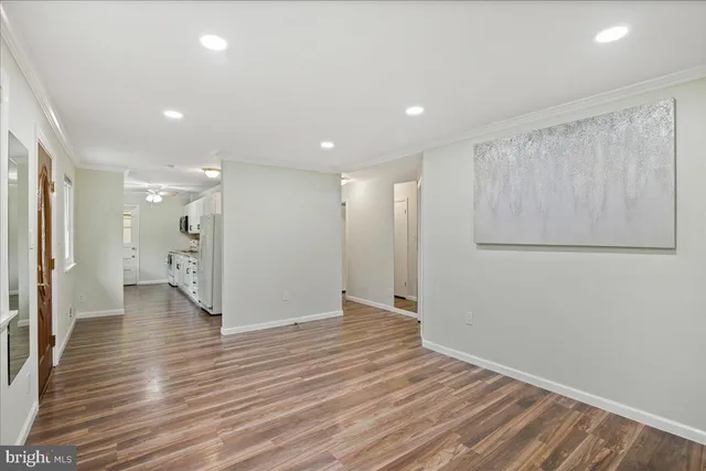 a view of an empty room with wooden floor