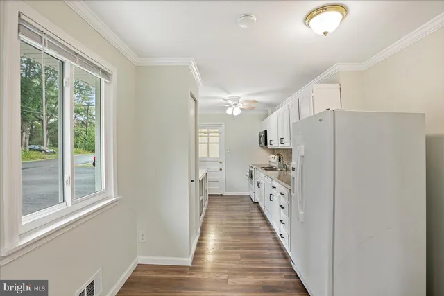 a view of a hallway with wooden floor and staircase