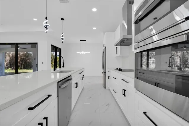 a large white kitchen with stainless steel appliances