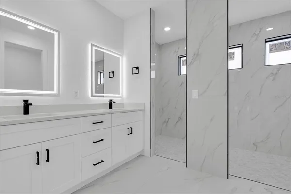 a spacious bathroom with double sink and shower