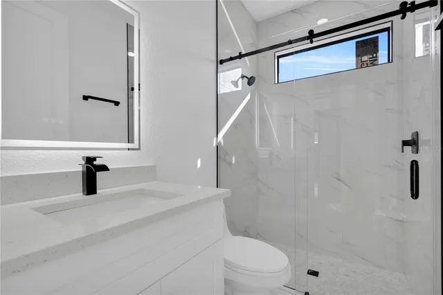 a bathroom with a granite countertop sink toilet and shower