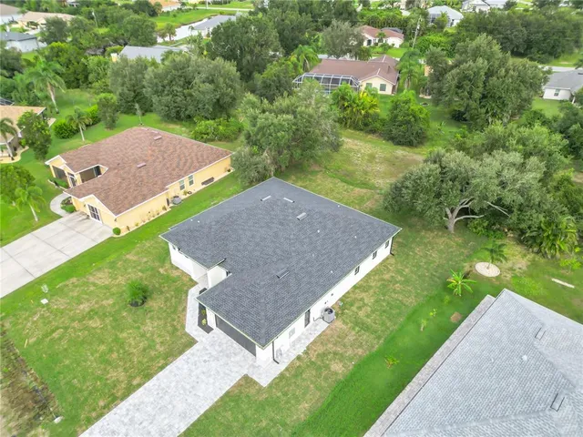 an aerial view of residential house with outdoor space and trees all around