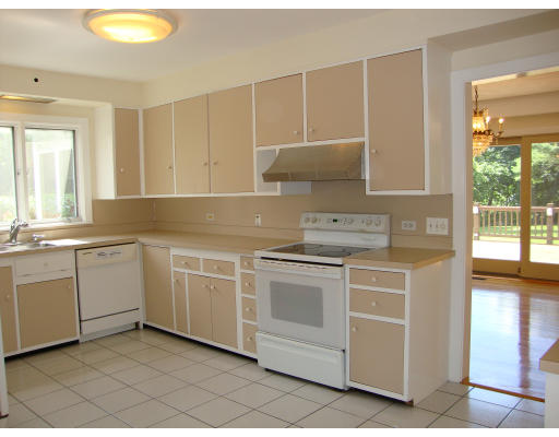 51 Cleveland Road Brookline, MA 02467 - Photo 8 of 15 a kitchen with white cabinets appliances and a window