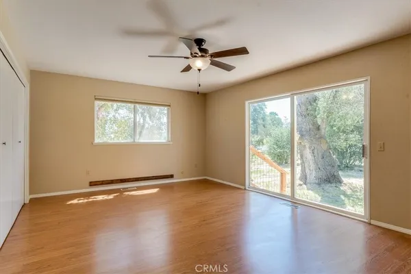 a view of a room with wooden floor and chandelier fan