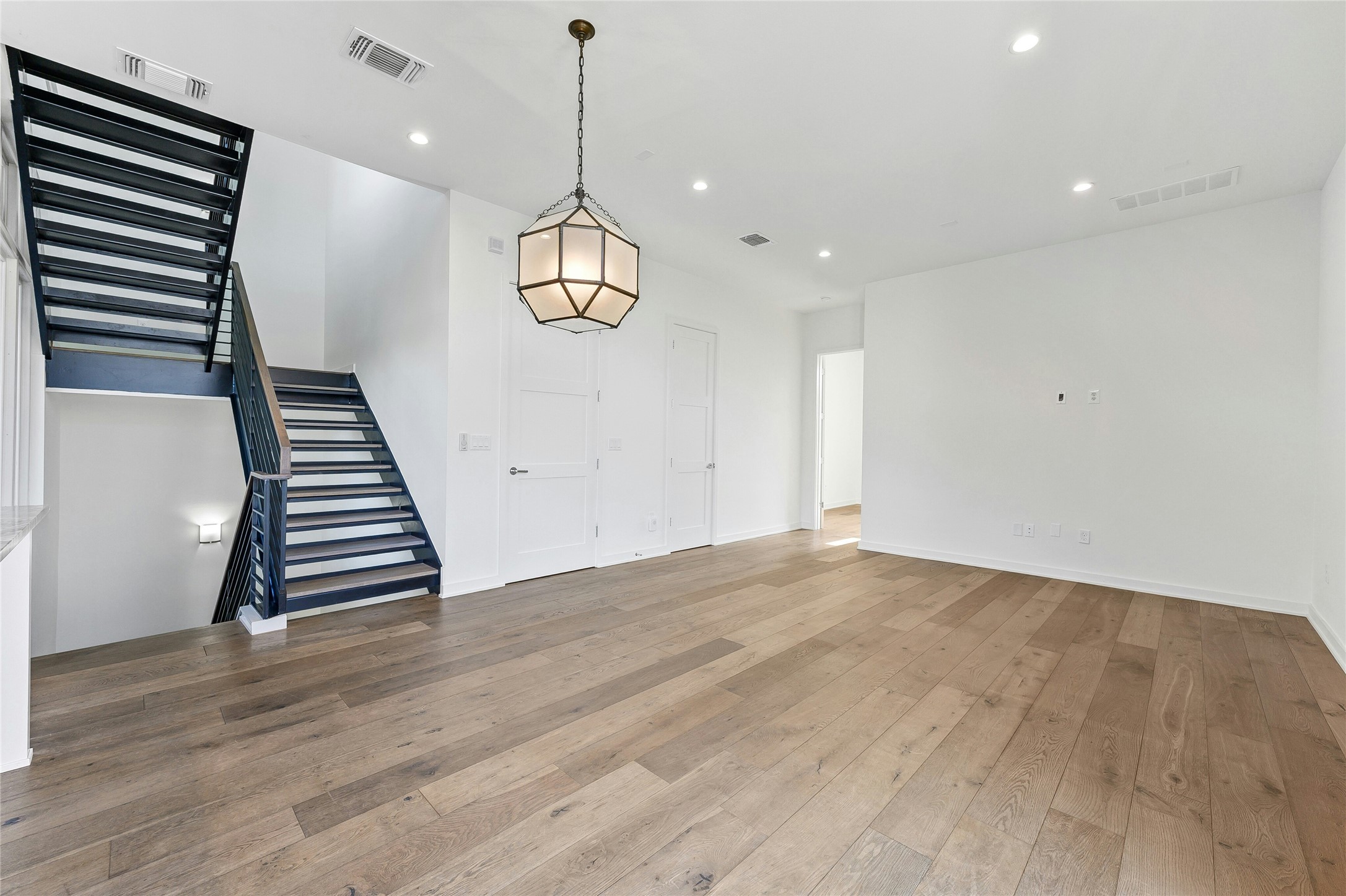 2518 Sutherland Street Austin, TX 78746 - Photo 6 of 30 Hardwood floors complement the striking contemporary staircase in this living space.