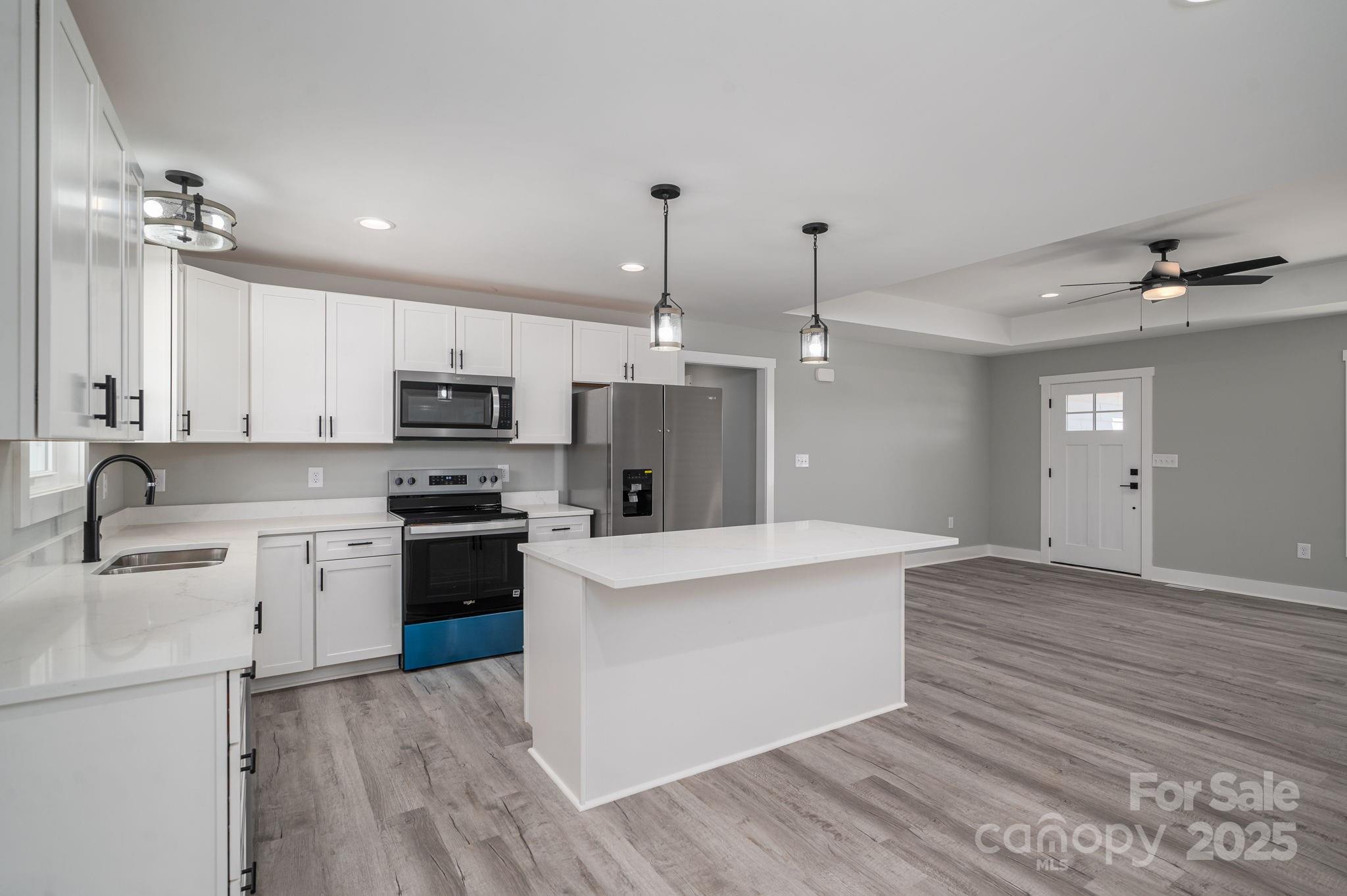 367 Northbrook III School Road Vale, NC 28168 - Photo 13 of 40 a kitchen with kitchen island a sink stove a refrigerator and white cabinets