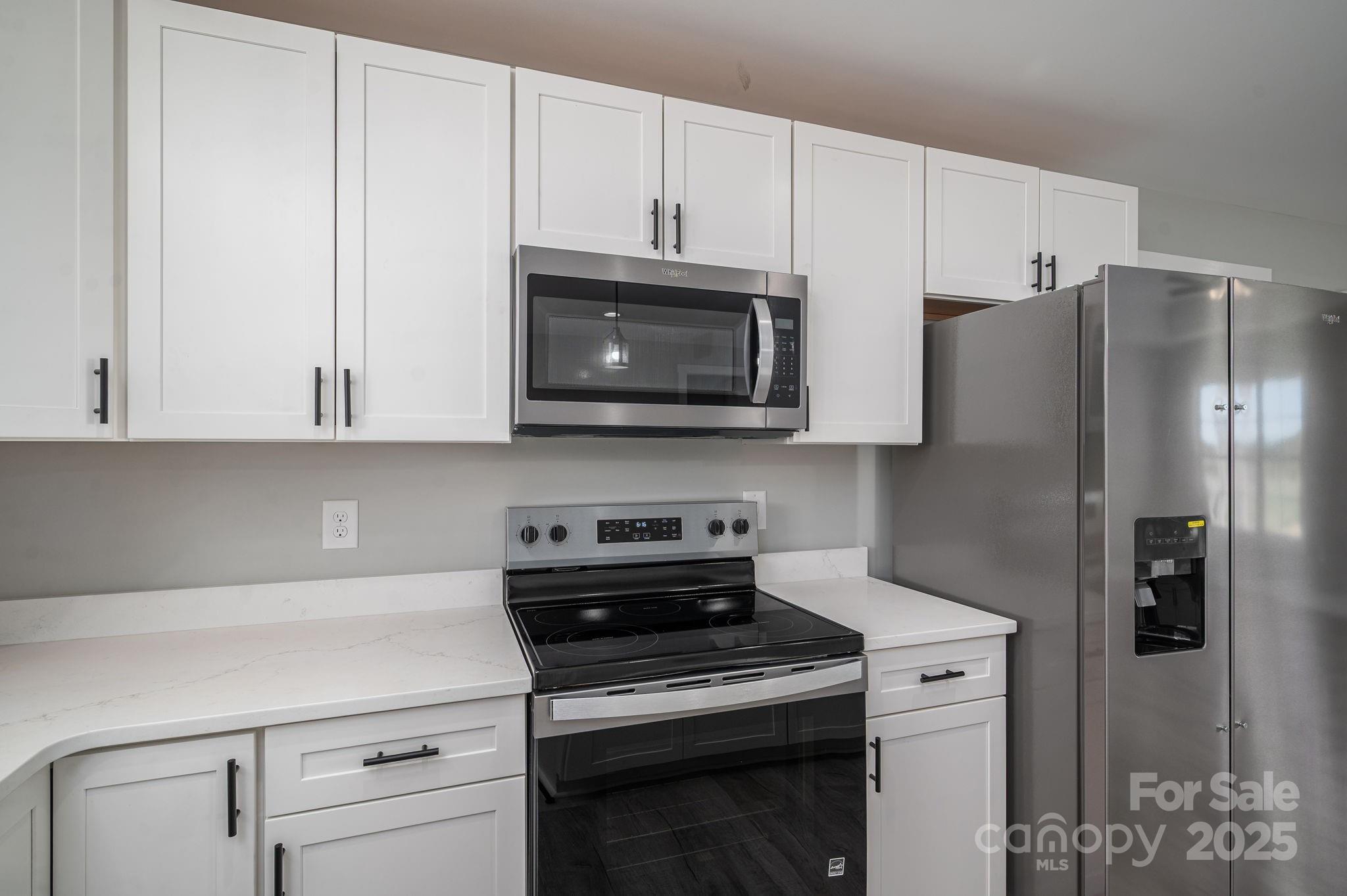 367 Northbrook III School Road Vale, NC 28168 - Photo 19 of 40 a kitchen with stainless steel appliances white cabinets and a stove a refrigerator with wooden floors