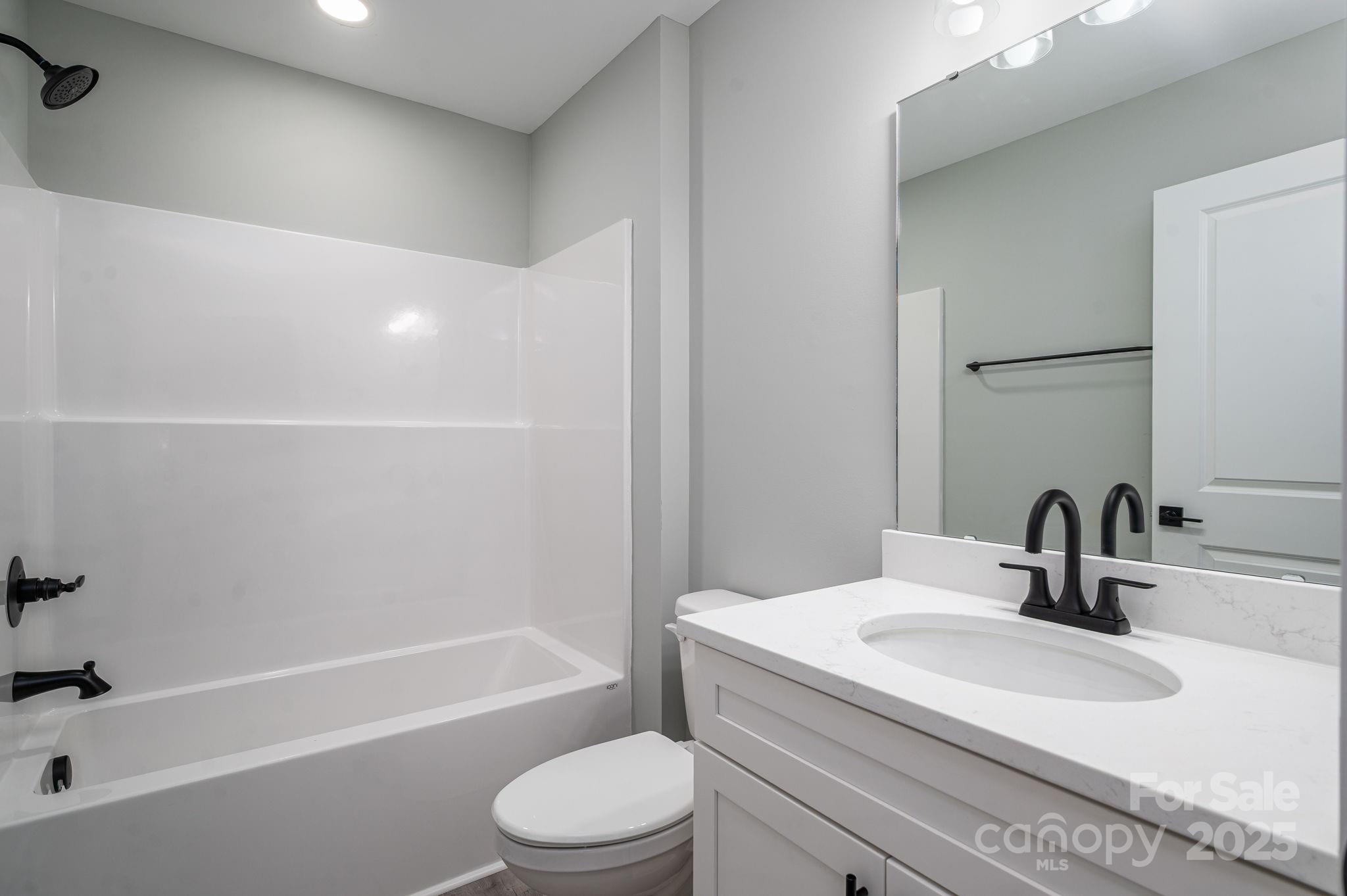 367 Northbrook III School Road Vale, NC 28168 - Photo 32 of 40 a bathroom with a granite countertop sink a toilet and bathtub