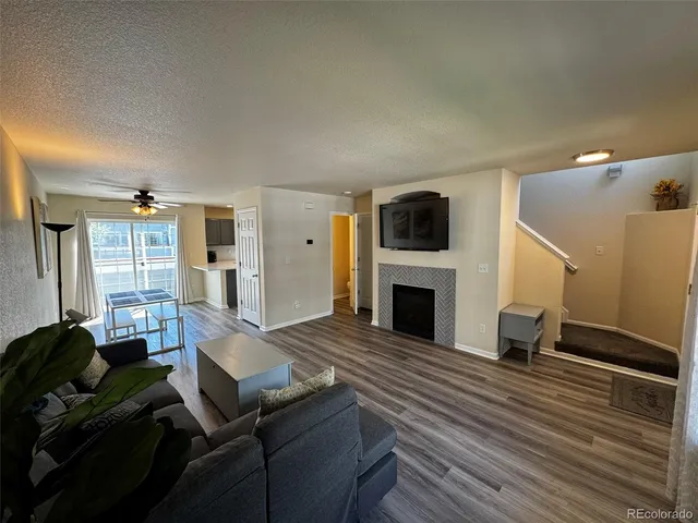 a living room with furniture a fireplace and a flat screen tv