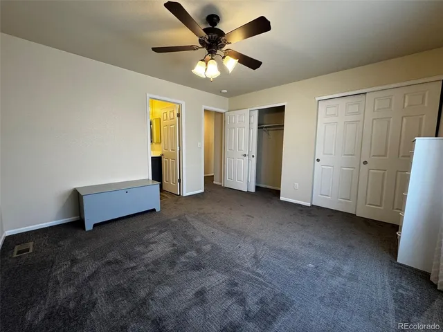 a view of a livingroom with a chandelier fan and a ceiling fan