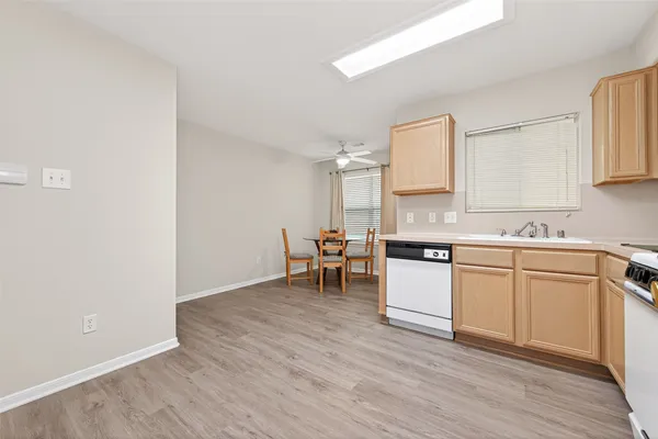 a kitchen with a sink cabinets and wooden floor