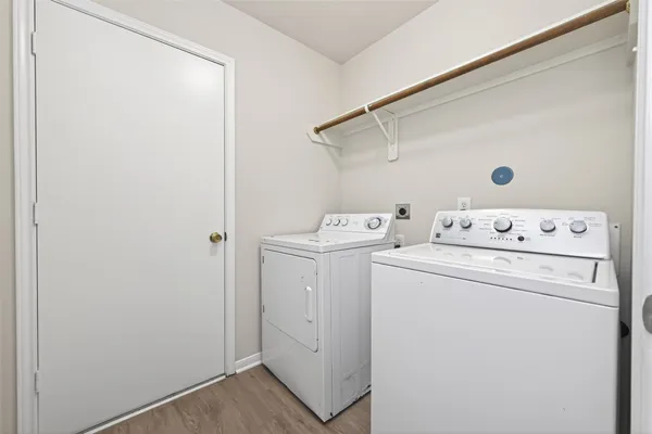 a view of washer and dryer with bathroom in the background