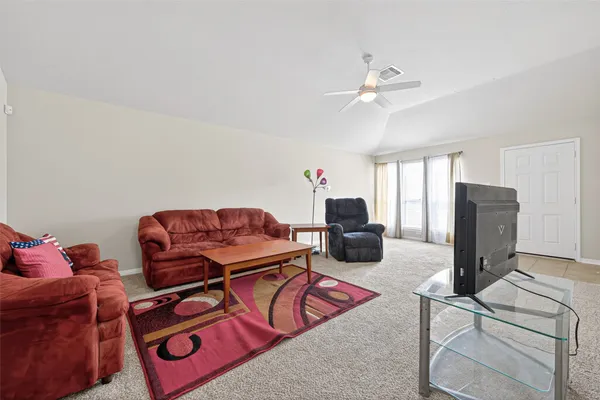 a living room with furniture a flat screen tv and a window
