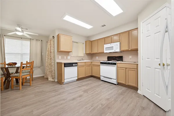 a kitchen with granite countertop white cabinets and white appliances