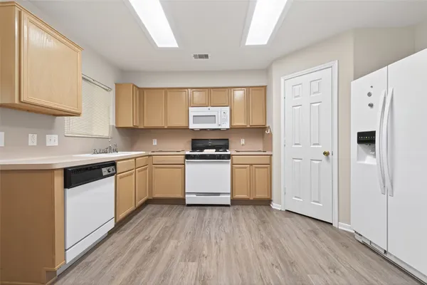 a kitchen with granite countertop white cabinets and white appliances