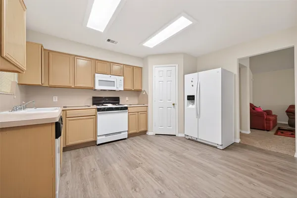 a kitchen with granite countertop a refrigerator and a stove top oven