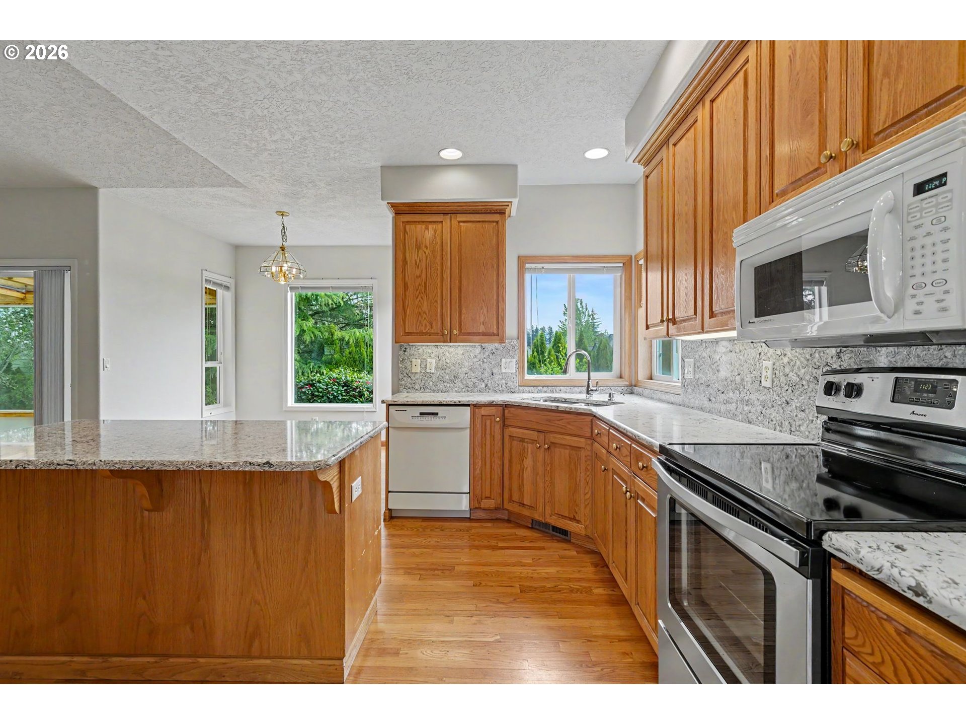 1470 Ranier Loop Northwest Salem, OR 97304 - Photo 14 of 48 a kitchen with stainless steel appliances granite countertop a sink a stove and a refrigerator